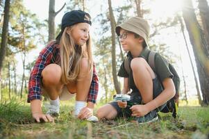 Kids exploring nature with magnifying glass. Summer activity for inquisitive child. photo