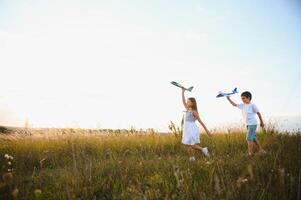 Active running kids with boy holding airplane toy. photo