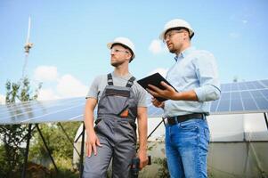 engineer and businessman planing new ecology project. around solar panel photo
