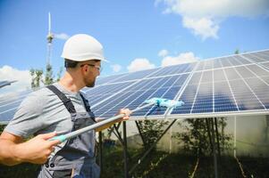 Worker cleaning solar panels after installation outdoors photo