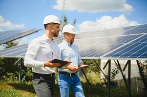 engineer and businessman planing new ecology project. around solar panel photo