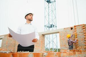 Construction concept of Engineer working at Construction Site with blue print. photo