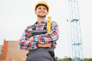 Construction worker in uniform and safety equipment have job on building photo