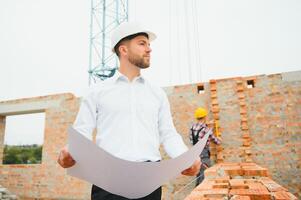 Construction concept of Engineer working at Construction Site with blue print. photo
