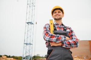 Communicating with crane guy. Construction worker in uniform and safety equipment have job on building. photo