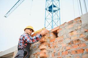 Communicating with crane guy. Construction worker in uniform and safety equipment have job on building. photo