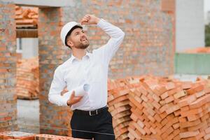 Engineering Consulting People on construction site holding blueprint in his hand. Building inspector. Construction site check drawing and business workflow of new building. photo