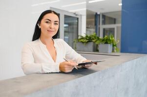 Portrait of beautiful receptionist near counter in hotel photo