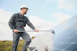 Worker cleaning solar panels after installation outdoors photo