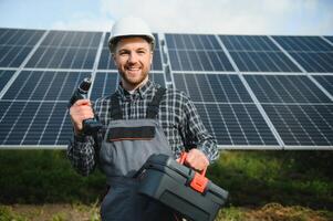 Professional worker installing solar panels on the metal construction, using different equipment, wearing helmet. Innovative solution for energy solving. Use renewable resources. Green energy. photo