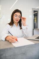 friendly young woman behind the reception desk administrator photo