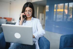 Smiling girl student study online with skype teacher, happy young woman learn language listen lecture watch webinar write notes look at laptop sit in cafe, distant education photo