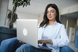 Smiling girl student study online with skype teacher, happy young woman learn language listen lecture watch webinar write notes look at laptop sit in cafe, distant education photo