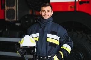 Portrait of a firefighter standing in front of a fire engine photo