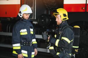 Portrait of two heroic fireman in protective suit and helmet. photo