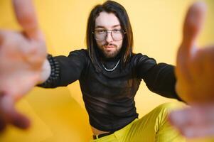 Young gay man is standing in the studio and posing for a camera. photo