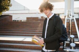 Excited student having break between classes near university, smiling to camera outdoors photo