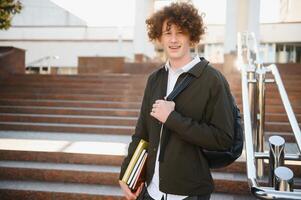 Excited student having break between classes near university, smiling to camera outdoors photo