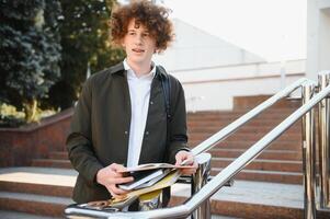 Excited student having break between classes near university, smiling to camera outdoors photo