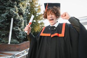 Excited male student in mantle scream graduate from university finish course studying. Happy man triumph holding college diploma in hands overjoyed with high school graduation. photo