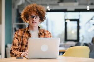 male programmer wear spectacles for eyes protection while working on freelance via laptop computer,clever student watching tutorial on netbook. photo