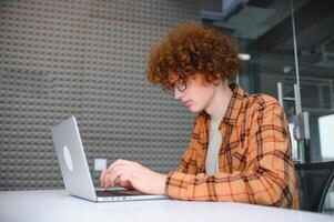 male programmer wear spectacles for eyes protection while working on freelance via laptop computer,clever student watching tutorial on netbook. photo