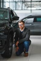 Man minded customer male buyer client in suit choose auto to go look aside want buy new automobile in car showroom vehicle salon dealership store motor show indoor Sales concept photo