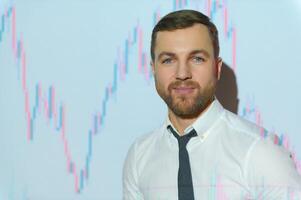 Man is standing near projector and showing graphs and business graphs. photo