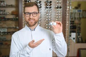 Doctor holds in his hand container with soft contact lenses for single use. Ophthalmologist prescribes use of one-day contact lenses for vision correction. Myopia and eyesight problem concept. photo