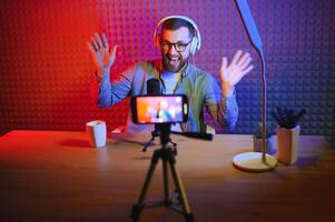 A blogger records content in his studio. The host of the blog is a young man who is very enthusiastic about telling his subscribers a story. photo