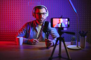 A blogger records content in his studio. The host of the blog is a young man who is very enthusiastic about telling his subscribers a story. photo