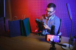 vlogger using smartphone to film podcast in studio. blogger with mobile phone, microphone and headphones filming for social media broadcasting career. photo