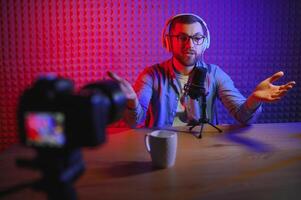 A blogger records content in his studio. The host of the blog is a young man who is very enthusiastic about telling his subscribers a story. photo