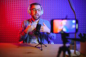 A blogger records content in his studio. The host of the blog is a young man who is very enthusiastic about telling his subscribers a story. photo