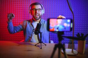 A blogger records content in his studio. The host of the blog is a young man who is very enthusiastic about telling his subscribers a story. photo