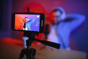 A blogger records content in his studio. The backstage photo was taken from behind one of the participants in the shooting, at the beginning of the shooting when the blogger is preparing.