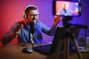 A blogger records content in his studio. The host of the blog is a young man who is very enthusiastic about telling his subscribers a story. photo