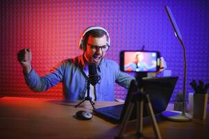 A blogger records content in his studio. The host of the blog is a young man who is very enthusiastic about telling his subscribers a story. photo