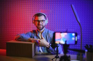 vlogger using smartphone to film podcast in studio. blogger with mobile phone, microphone and headphones filming for social media broadcasting career. photo