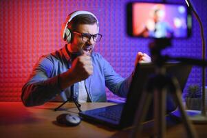 A blogger records content in his studio. The host of the blog is a young man who is very enthusiastic about telling his subscribers a story. photo