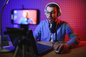 A blogger records content in his studio. The host of the blog is a young man who is very enthusiastic about telling his subscribers a story. photo