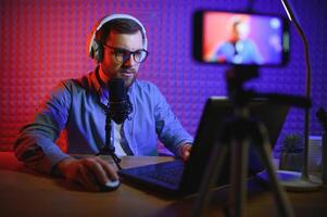 A blogger records content in his studio. The backstage photo was taken from behind one of the participants in the shooting, at the beginning of the shooting when the blogger is preparing.