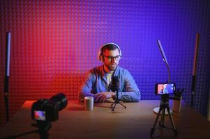 A blogger records content in his studio. The backstage photo was taken from behind one of the participants in the shooting, at the beginning of the shooting when the blogger is preparing.