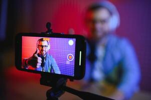 A blogger records content in his studio. The backstage photo was taken from behind one of the participants in the shooting, at the beginning of the shooting when the blogger is preparing.