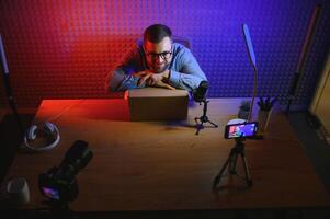 vlogger using smartphone to film podcast in studio. blogger with mobile phone, microphone and headphones filming for social media broadcasting career. photo