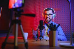 A blogger records content in his studio. The host of the blog is a young man who is very enthusiastic about telling his subscribers a story. photo