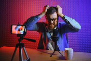 A blogger records content in his studio. The host of the blog is a young man who is very enthusiastic about telling his subscribers a story. photo