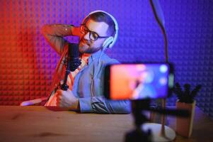 A blogger records content in his studio. The host of the blog is a young man who is very enthusiastic about telling his subscribers a story. photo