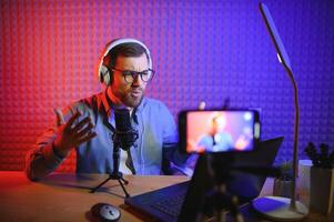 A blogger records content in his studio. The host of the blog is a young man who is very enthusiastic about telling his subscribers a story. photo