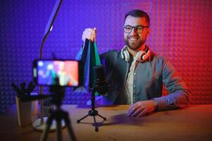 vlogger using smartphone to film podcast in studio. blogger with mobile phone, microphone and headphones filming for social media broadcasting career. photo